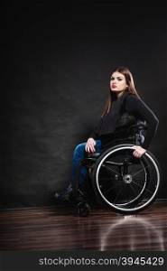 Real people, healthcare and medicine. Sad young woman invalid girl sitting on wheelchair studio shot on black
