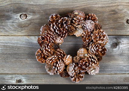 Real pine cone wreath for the Christmas season on rustic wooden boards