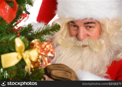 Real Santa Claus decorating Christmas tree at home closeup portrait