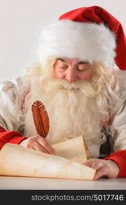 Real Santa Claus writing list of gifts or responding to children's letters on old paper scroll, isolated on white background