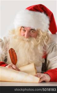 Real Santa Claus writing list of gifts or responding to children's letters on old paper scroll, isolated on white background