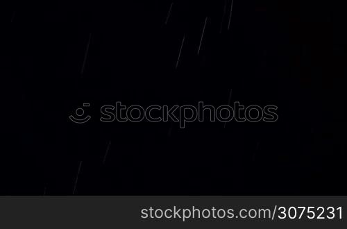 Real shot of pouring rain and falling snow during night thunderstorm, lightnings flashing in the sky
