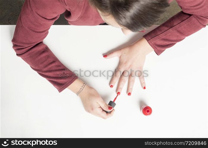 Real woman panting her nails in red color