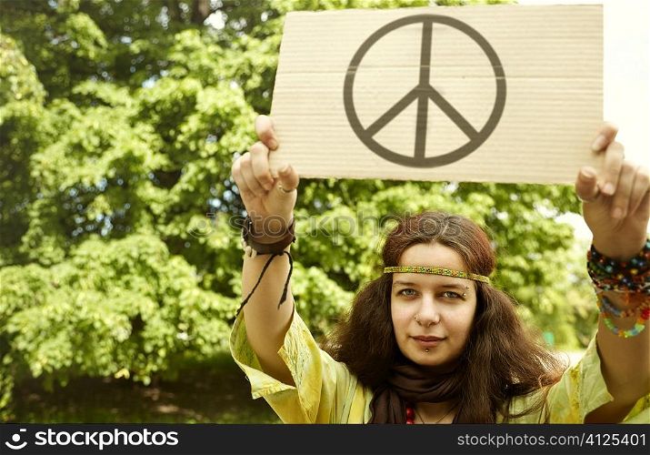 real young woman with cardboard with well-known peice symbol,selective focus on eye