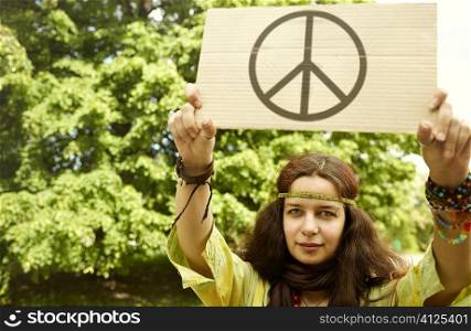 real young woman with cardboard with well-known peice symbol,selective focus on eye