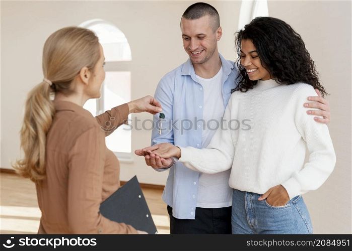 realtor handing smiley couple keys their new home