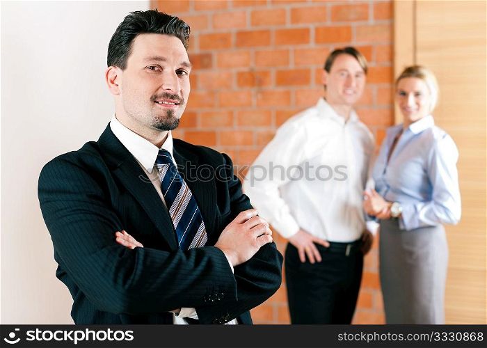 Realtor in an empty apartment with some clients looking for real estate