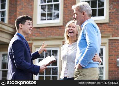 Realtor Showing Mature Couple Around House For Sale