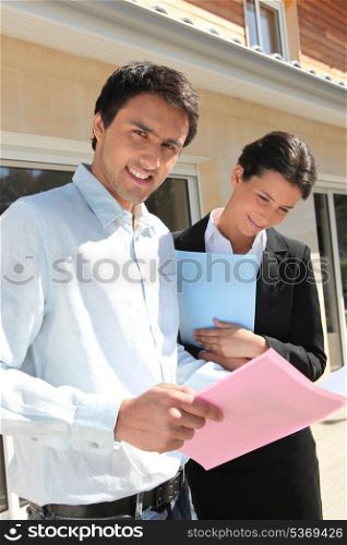 Realty promoters standing in front of a house