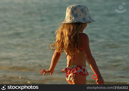 Rear of a young girl on a beach, Moorea, Tahiti, French Polynesia, South Pacific