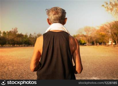 Rear of Asian senior man jogging in the park for good health. Healthcare concept.