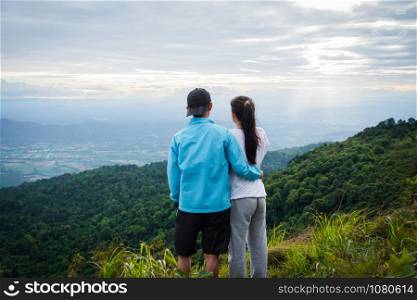 rear of couple love feel happy woman stand on top mountain looking view with mist and cloud