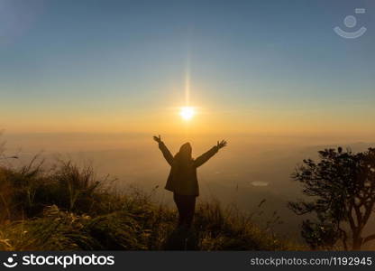 rear of happy woman stand on top mountain looking view with sunrise and mist at (Doi Norg Doi Luang National Park) Phayao province. soft focus.