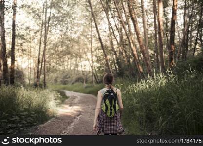 rear vie woman walking dirt road forest