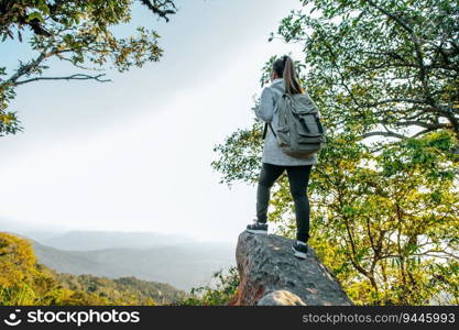 Rear view back of Young asian hiking female standing at view point and looking beautiful view with happy on peak mountain and sunray,  copy space