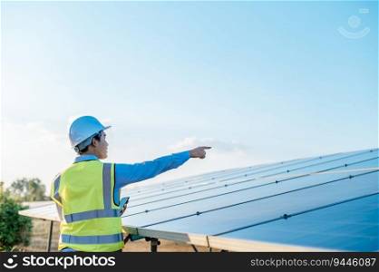 Rear view, back of young Asian technician man pointing finger while checking operation photovoltaic solar panel, copy space