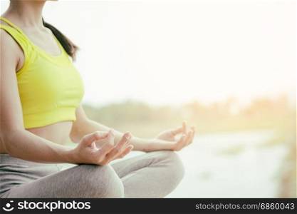 Rear view close up of woman perform meditating yoga on the nature background in the morning