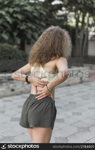 rear view female athlete having back pain