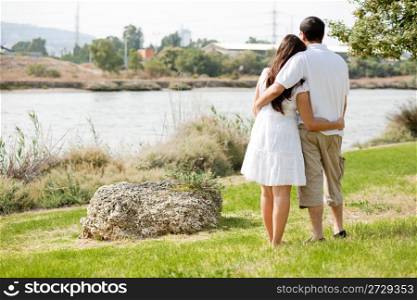 Rear view full section of couple holding eachother in green field