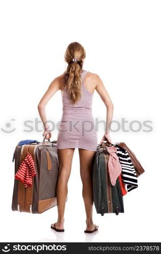 Rear view of a beautiful and young woman carying the baggage with clothes