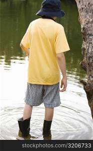 Rear view of a boy standing in water