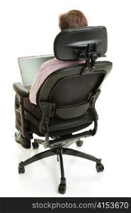 Rear view of a business man sitting in an ergonomic chair and using his computer. Full body isolated on white.