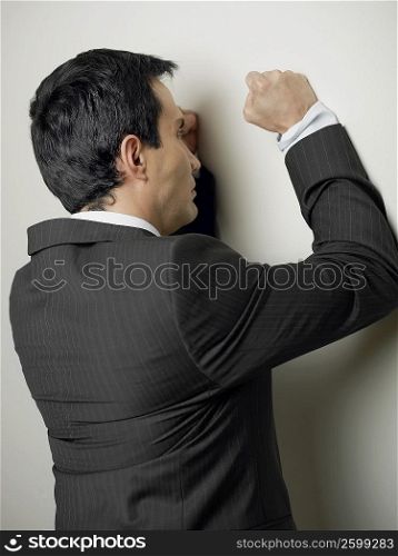 Rear view of a businessman hitting a wall