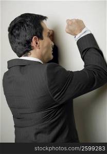 Rear view of a businessman hitting a wall