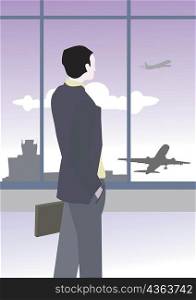 Rear view of a businessman looking at an airplane