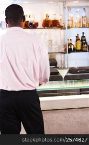 Rear view of a businessman standing at a bar counter