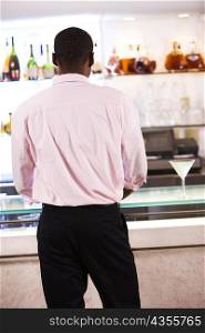 Rear view of a businessman standing in a bar