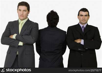 Rear view of a businessman standing with two businessmen with their arms crossed