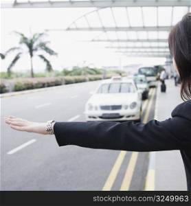Rear view of a businesswoman hailing a taxi
