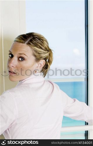 Rear view of a businesswoman standing beside a window