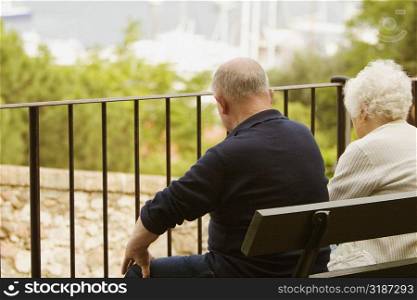 Rear view of a couple sitting on the bench, Vieux Port, Cote d&acute;Azur, Cannes, Provence-Alpes-Cote D&acute;Azur, France