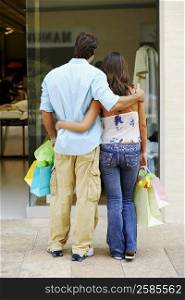 Rear view of a couple standing in front of a store