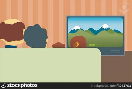 Rear view of a family watching television