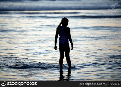 Rear view of a girl standing on the beach, San Diego, California, USA
