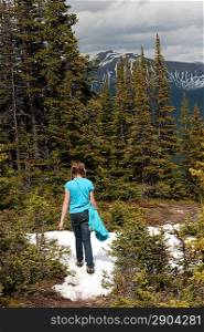 Rear view of a girl walking on snow covered trail, Bald Hills, Jasper National Park, Alberta, Canada