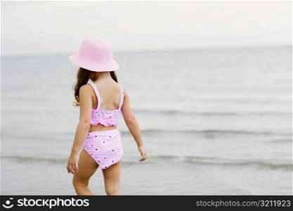 Rear view of a girl walking on the beach