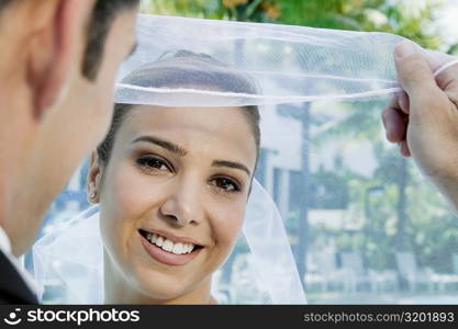 Rear view of a groom lifting his bride&acute;s veil