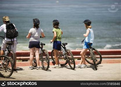 Rear view of a group of cyclists looking at the sea, La Jolla, San Diego, California, USA