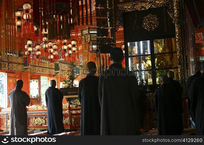 Rear view of a group of people praying in a monastery, Po Lin Monastery, Ngong Ping, Lantau, Hong Kong, China