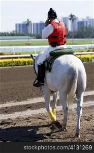Rear view of a jockey riding a horse