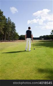 Rear view of a male golfer on the fairway