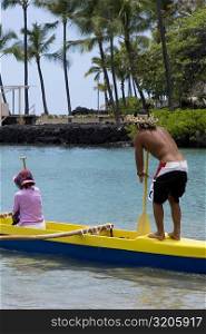 Rear view of a man and a woman canoeing in the sea, Captain Cook&acute;s Monument, Kealakekua Bay, Kona Coast, Big Island, Hawaii islands, USA