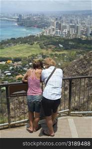 Rear view of a man and a woman standing at an observation point, Diamond Head, Waikiki Beach, Honolulu, Oahu, Hawaii Islands, USA