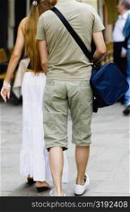 Rear view of a man and a woman walking