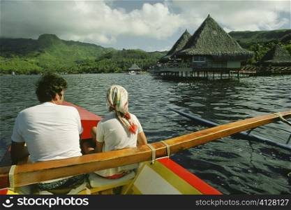Rear view of a man and woman in a boat, Raiatea Island, Tahiti, Society Islands, French Polynesia