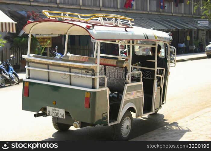 Rear view of a man driving a jinrikisha, Vientiane, Laos